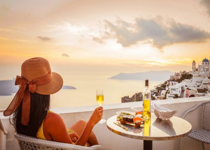 Woman drinking wine in Santorini - credits: Littleaom/Shutterstock.com
